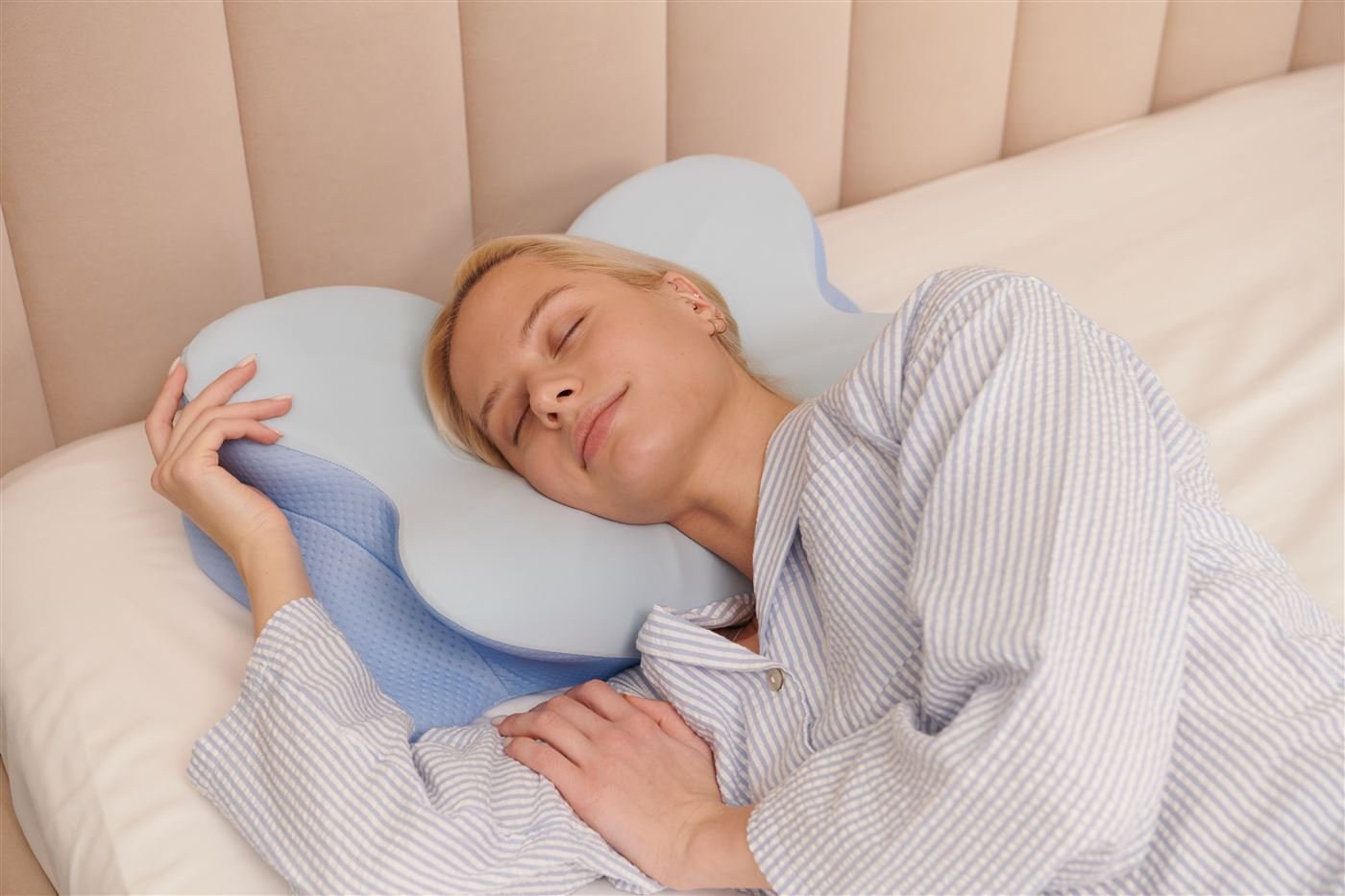 Woman sleeping on her side on the butterfly-shaped Derila Ergo pillow