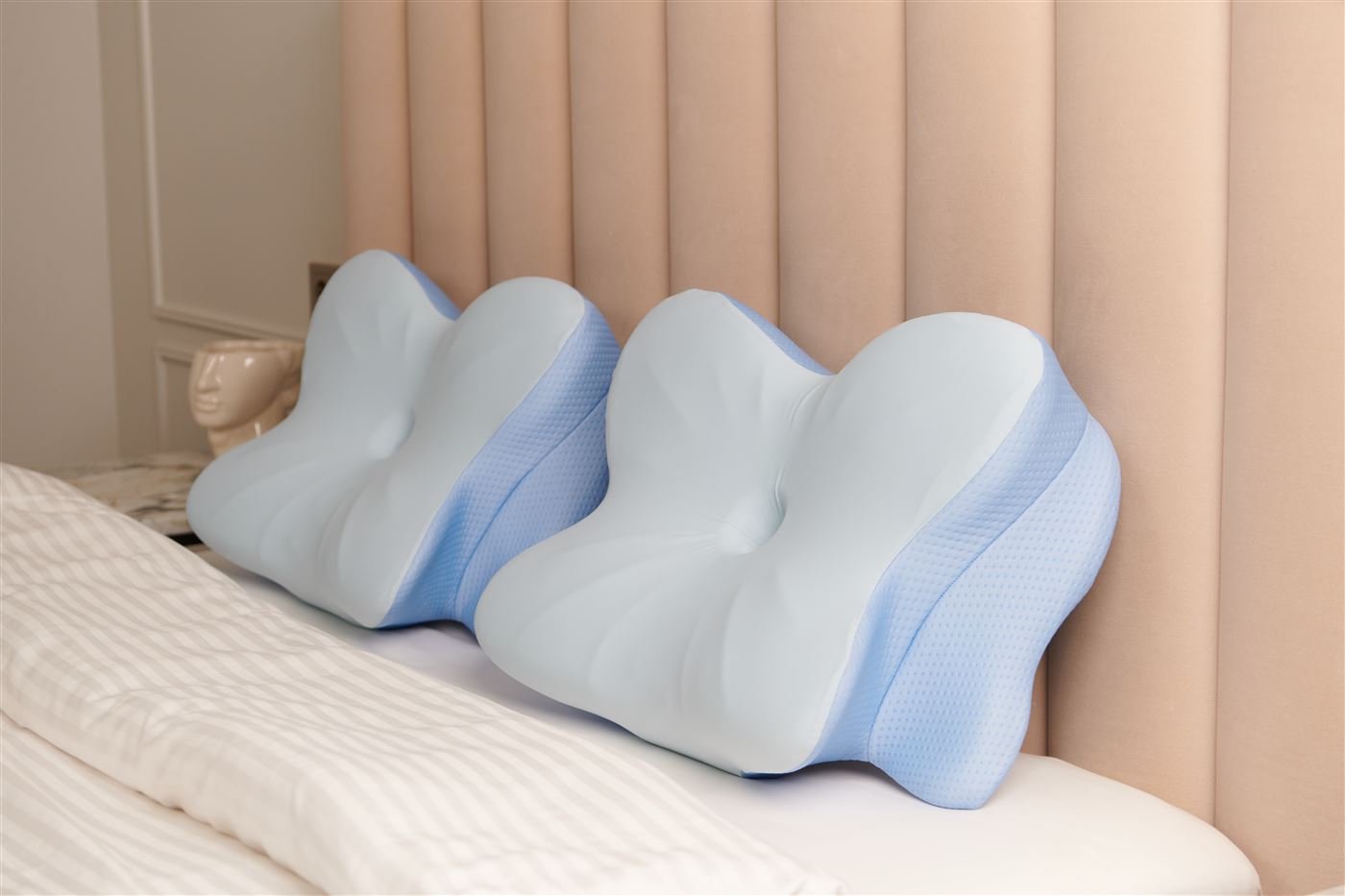 Two Derila Ergo pillows side by side on a bed, showing the raised side wings